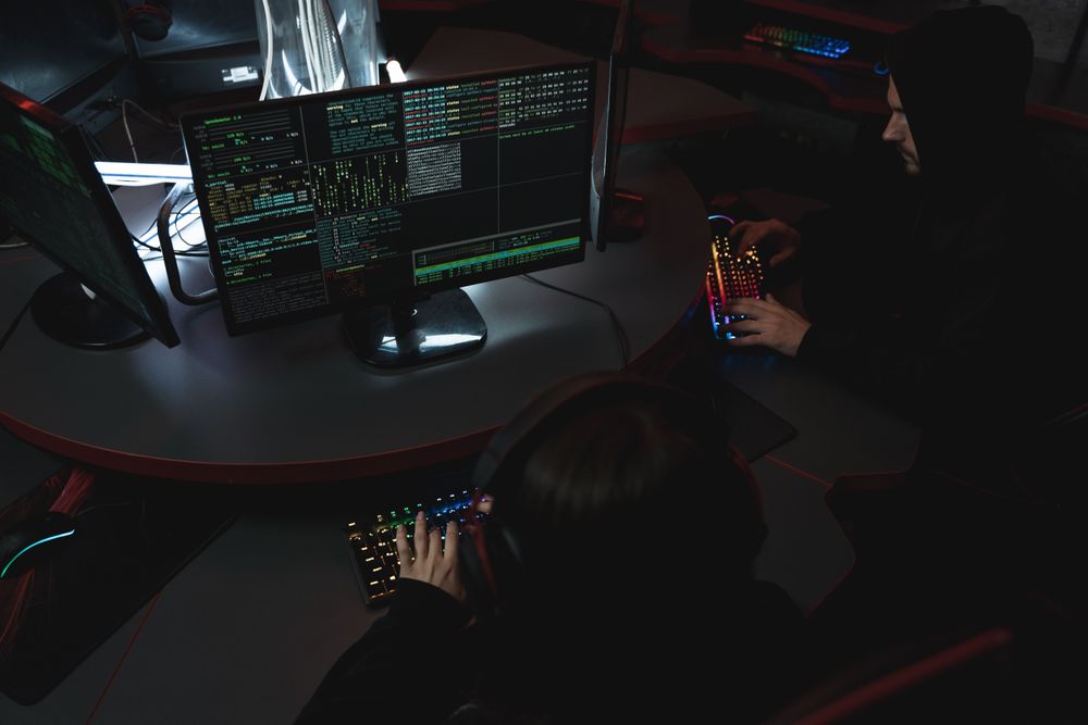Hacker sitzen am Schreibtisch und arbeiten am PC