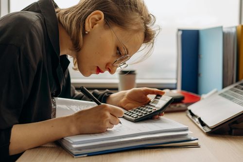 Eine Finanzamtmitarbeiterin prüft die Dokumente eines Unternehmens